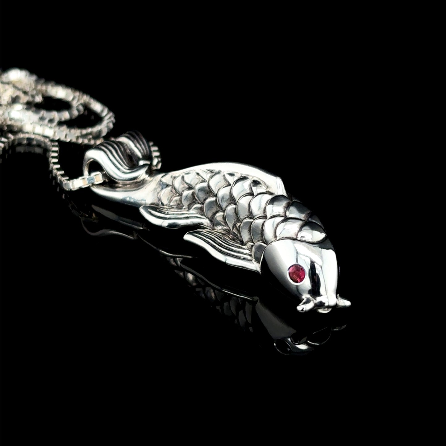 Fish necklace is solid sterling silver with natural garnet eyes